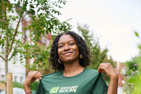 Women looking at the camera smiling and showing off her Anthony Nolan T-shirt