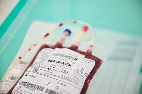 Blood sample bag with white label, on aqua tray.