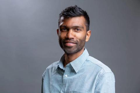 Headshot of a South Asian man smiling looking at the camera