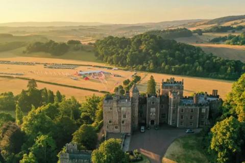 Photo of some scenery which has a castle, fields, and trees