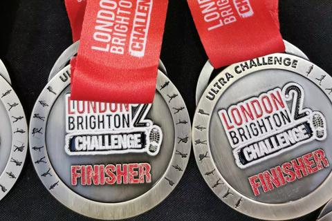 Photo of a medal which says London 2 Brighton Challenge and has a red ribbon