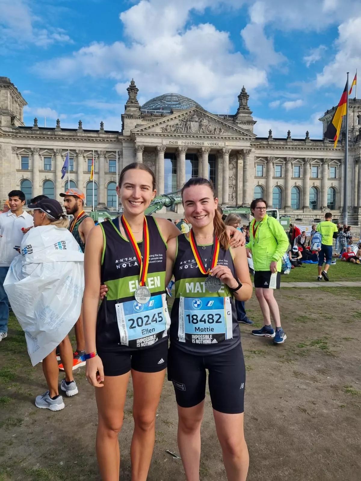 Two female supporters celebrating with medals after completing the Berlin Marathon for Anthony Nolan