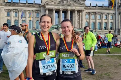 Two female supporters celebrating with medals after completing the Berlin Marathon for Anthony Nolan
