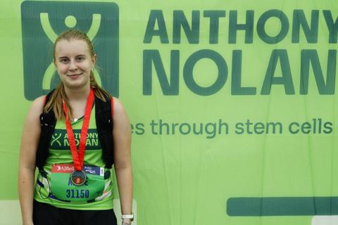 a young woman in an Anthony Nolan running vest wearing a medal
