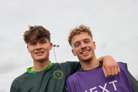 Two football players hugging, one in an Anthony Nolan football kit and one in a NEXT branded top