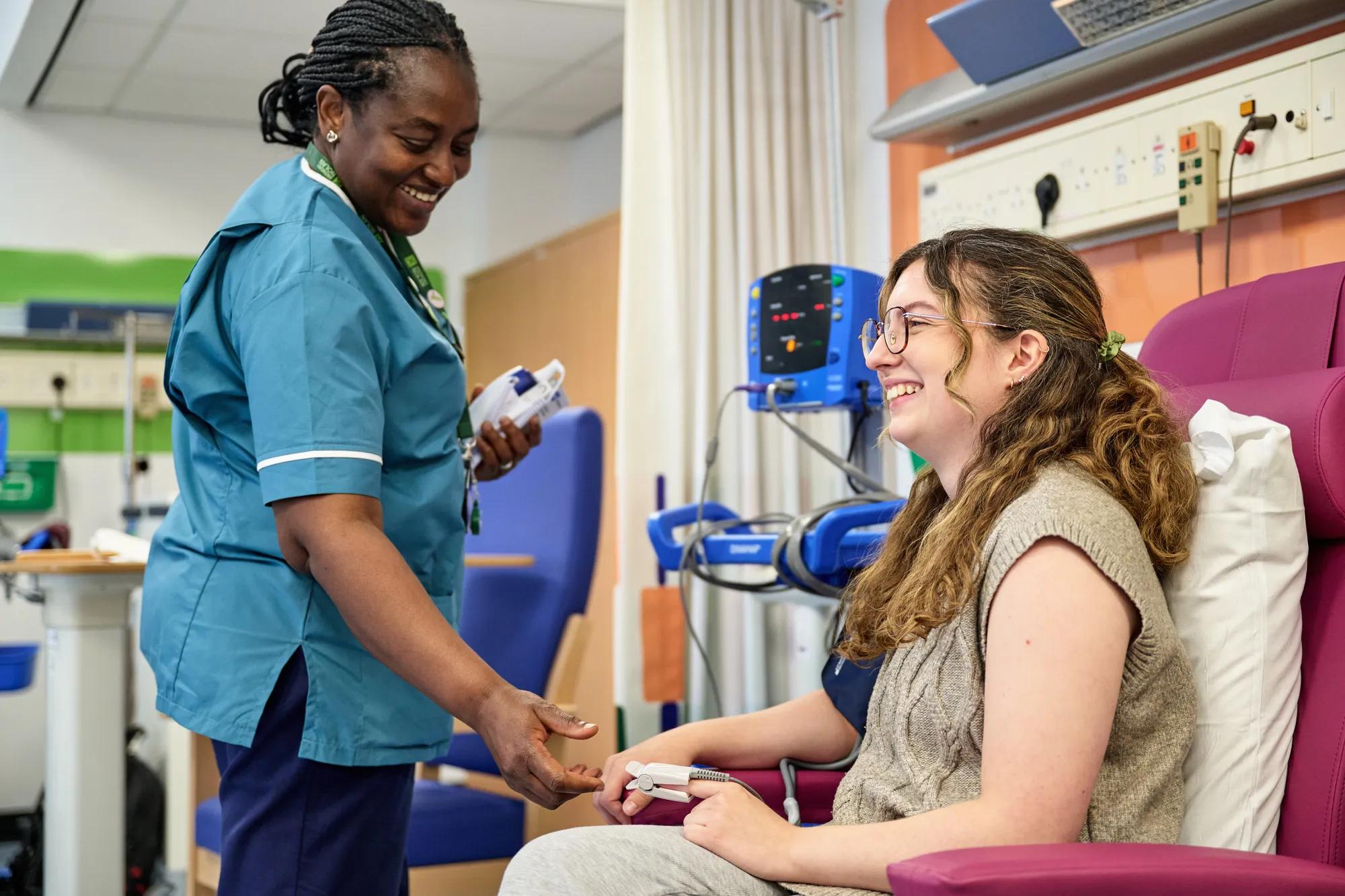 Donor sits on chair while nurse takes their blood pressure.