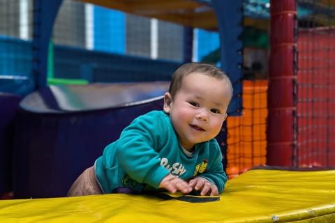 A phot of Ismail smiling at the camera, taken at a kids soft play.