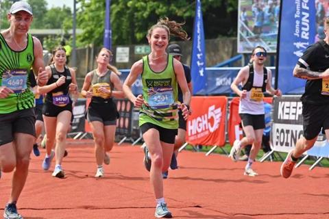 Photo of a woman smiling in her green anthony nolan running vest