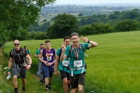 Photo of a group of people smiling at the camera as they are walking and taking on the Chiltern 50 Challenge